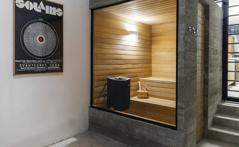 sauna seca de madeira com aquecedor, bancos e fechamento em vidro.